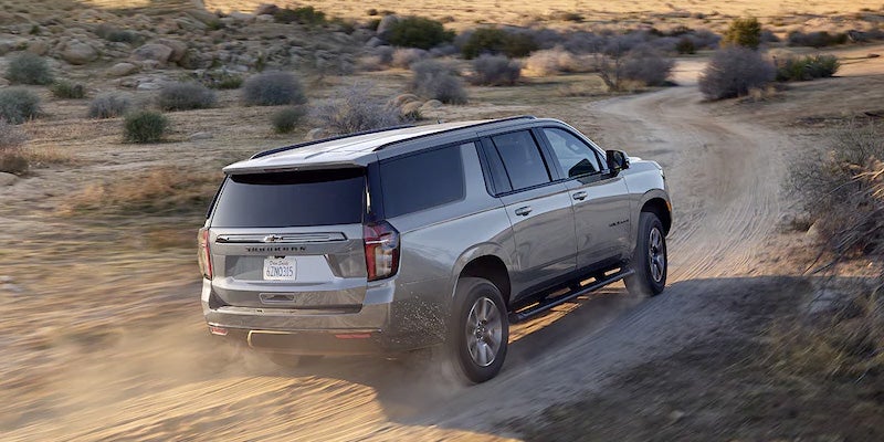 Chevrolet Suburban driving on dirt road