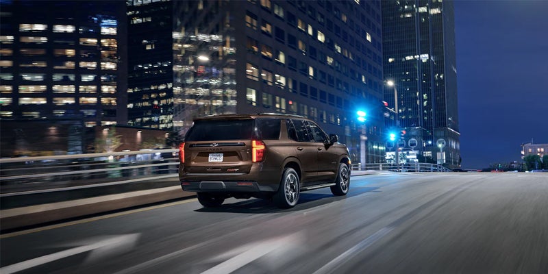 Brown Chevrolet Tahoe driving at night city streets