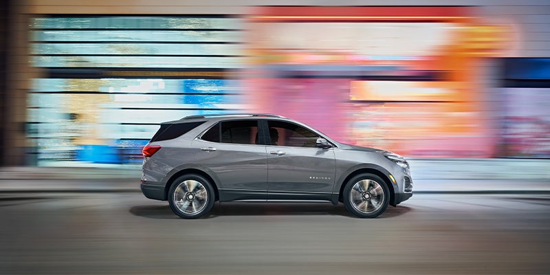 Silver Chevrolet Equinox running on road side