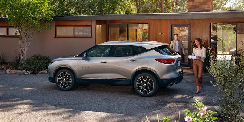 Woman and Man approaching Chevy Blazer in driveway